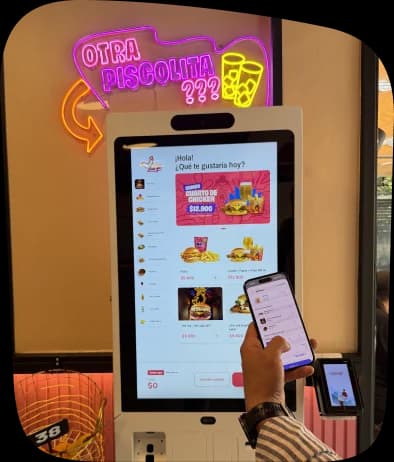 Una clienta pide en el tótem de Chicken Love You con el celular en la mano